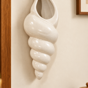 Cream ceramic shell-shaped wall mounted planter with glossy speckled finish