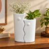 Modern white ceramic vase set of 2 with sculptural wavy design styled on a wooden console table